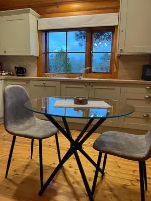 a glass table and two chairs in a kitchen at Romantic Log Cabin With Hot Tub in Leominster