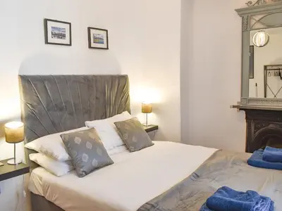 a bedroom with a large white bed and a fireplace at Tryfar House in Harlech