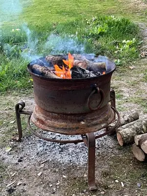 a fire pit in the grass with smoke coming out at Tranquil 1 bedroom cottage 15 mins drive to sea in Mydroilin