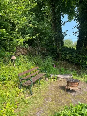 a park bench and a bird bath in a park at Tranquil 1 bedroom cottage 15 mins drive to sea in Mydroilin