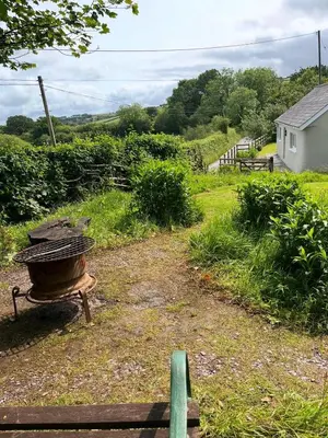a grill in a field with a house in the background at Tranquil 1 bedroom cottage 15 mins drive to sea in Mydroilin