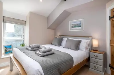 a bedroom with a large bed with towels on it at Seagrass Cottage - Aberdovey in Aberdyfi