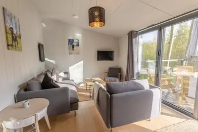 a living room with two couches and a table at Riverside Cabins in Shrewsbury