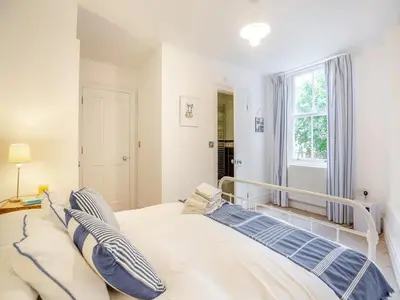 a bedroom with a large bed with blue and white pillows at Seaview Apartment Westhaven in Aberdyfi