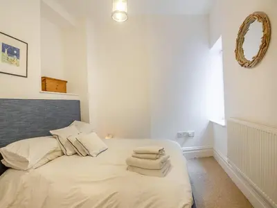 a bedroom with a bed with towels on it at Seaview Apartment Westhaven in Aberdyfi