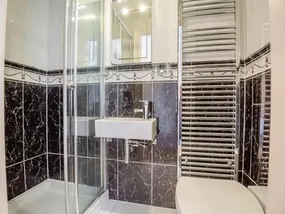 a bathroom with a toilet and a sink and a shower at Seaview Apartment Westhaven in Aberdyfi