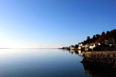 a large body of water with houses on the shore at Seaview Apartment Westhaven in Aberdyfi