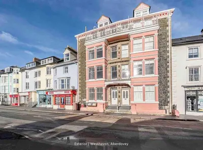 a red and white building on a city street at Seaview Apartment Westhaven in Aberdyfi