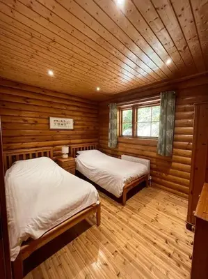 a bedroom with two beds in a log cabin at Solid Log Cabin With Private Hot Tub - Oak in Aymestrey