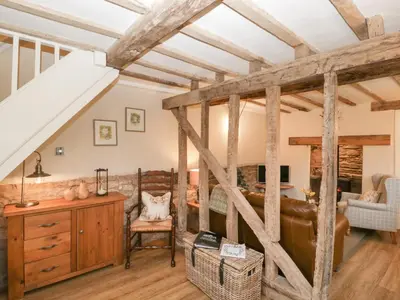 a living room with wooden beams at Pool Cottage in Hereford