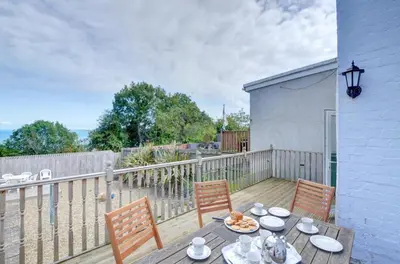 a wooden deck with a table and two chairs at 4 Bed in New Quay oc-was409 in New Quay