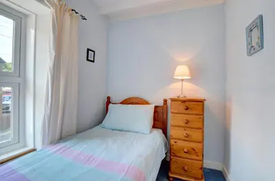 a bedroom with a bed and a dresser and a window at 4 Bed in New Quay oc-was409 in New Quay