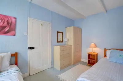 a bedroom with a bed and a dresser and a door at 4 Bed in New Quay oc-was409 in New Quay