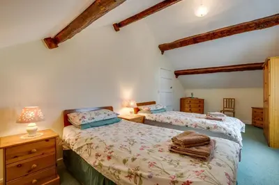 a bedroom with two beds and a dresser with two lamps at 2 Bed in Barmouth oc-wah699 in Talybont
