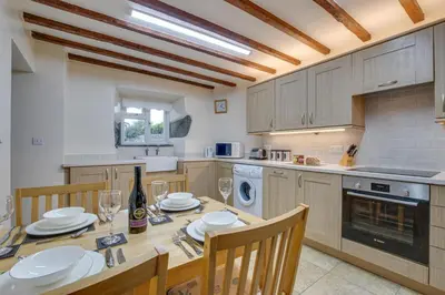 a kitchen with a wooden table and chairs and a kitchen with a table and chairs at 2 Bed in Barmouth oc-wah699 in Talybont