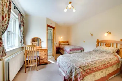 a bedroom with two beds and a desk and a mirror at 5 Bed in Aberystwyth oc-wan443 in Llanychaiarn