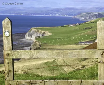 a wooden fence with a view of the ocean at 1 Bed in Aberystwyth oc-bow182 in Rhostie