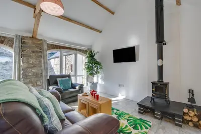 a living room with a couch and a wood stove at 1 Bed in Aberystwyth oc-bow182 in Rhostie