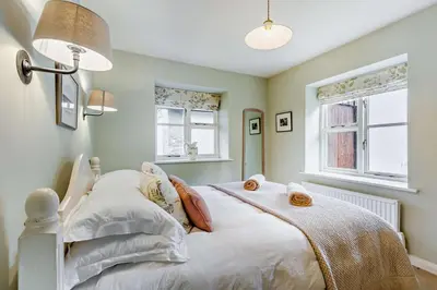 a bedroom with a white bed and two windows at 4 Bed in Builth Wells oc-bow197 in Builth Wells