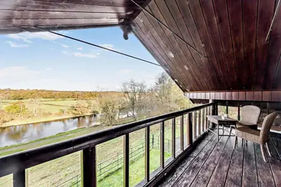 a balcony with two chairs and a view of a river at 4 Bed in Builth Wells oc-bow197 in Builth Wells