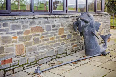 a statue of a fire hydrant next to a brick wall at 4 Bed in Builth Wells oc-bow197 in Builth Wells
