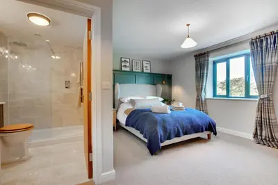 a bedroom with a bed and a bathroom with a shower at 2 Bed in Builth Wells oc-bow198 in Builth Wells