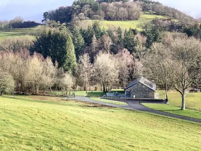a barn in a field with trees and a road at 2 Bed in Builth Wells oc-bow198 in Builth Wells
