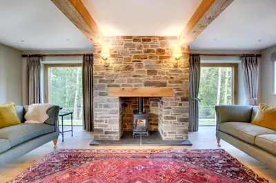 a stone fireplace in a living room with two couches at 2 Bed in Builth Wells oc-bow198 in Builth Wells