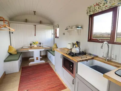 a small kitchen with white cabinets and a sink at Balwen Shepherd's Hut in Montgomery