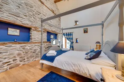 a bedroom with a bed and a stone wall at 4 Bed in Llanarmon Dyffryn Ceiriog oc-bow152 in Llanarmon Dyffryn-Ceiriog