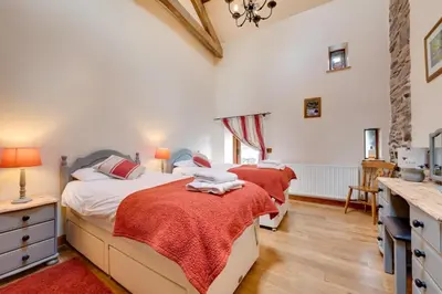 two beds in a bedroom with a desk and a sink at 4 Bed in Llanarmon Dyffryn Ceiriog oc-bow152 in Llanarmon Dyffryn-Ceiriog