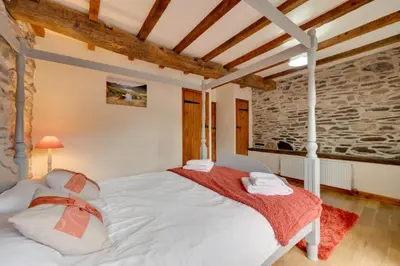 a bedroom with a white bed and a brick wall at 4 Bed in Llanarmon Dyffryn Ceiriog oc-bow151 in Llanarmon Dyffryn-Ceiriog