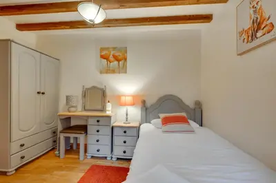 a bedroom with a bed and a desk and a mirror at 4 Bed in Llanarmon Dyffryn Ceiriog oc-bow151 in Llanarmon Dyffryn-Ceiriog