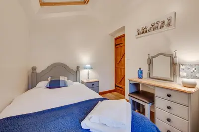 a bedroom with a blue and white bed and a desk at 4 Bed in Llanarmon Dyffryn Ceiriog oc-bow151 in Llanarmon Dyffryn-Ceiriog