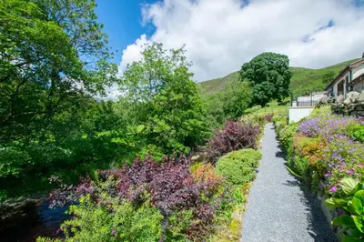 a path through a garden with flowers at 4 Bed in Llanarmon Dyffryn Ceiriog oc-bow151 in Llanarmon Dyffryn-Ceiriog