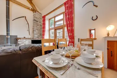 a dining room with a table with wine glasses on it at 4 Bed in Llanarmon Dyffryn Ceiriog oc-bow151 in Llanarmon Dyffryn-Ceiriog