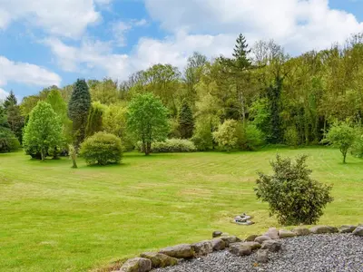 a person laying on the grass in a field at Goitre Farmhouse in Llanwrda