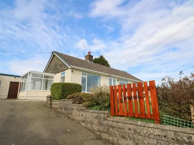 a house with a red gate in front of it at Gwynant in Ystrad Meurig